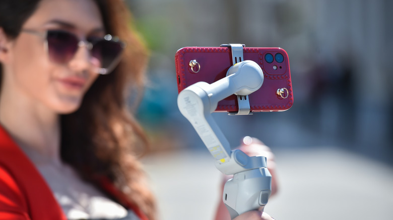 A person using a gimbal connected to a phone
