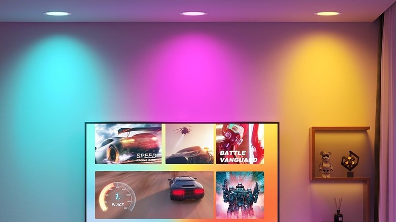 Three colored downlights above a TV, one cyan, one magenta, and one yellow.