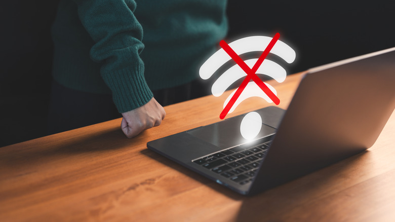 No WiFi holographic symbol above a laptop