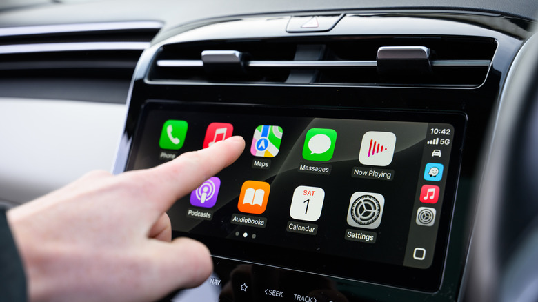 Hand interacting with Apple CarPlay in vehicle