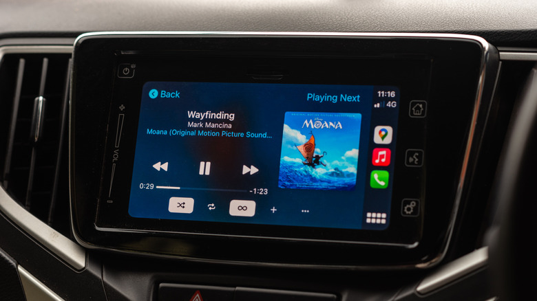 Apple Music CarPlay display on an automobile multimedia player with a view of the dashboard