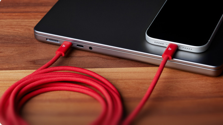 Red beats by dre usb c cable connecting an iPhone to a MacBook pro laptop