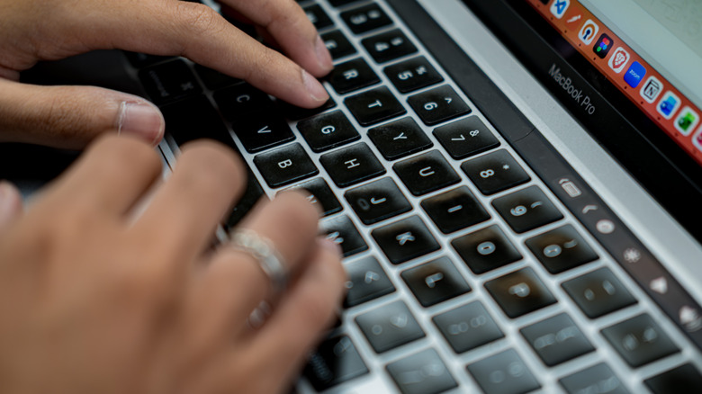 Person typing on a MacBook Pro keyboard