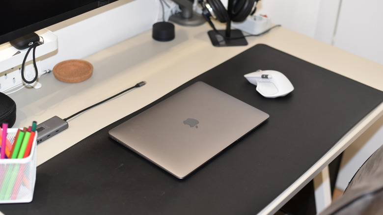 Macbook on a desk with a few accessories