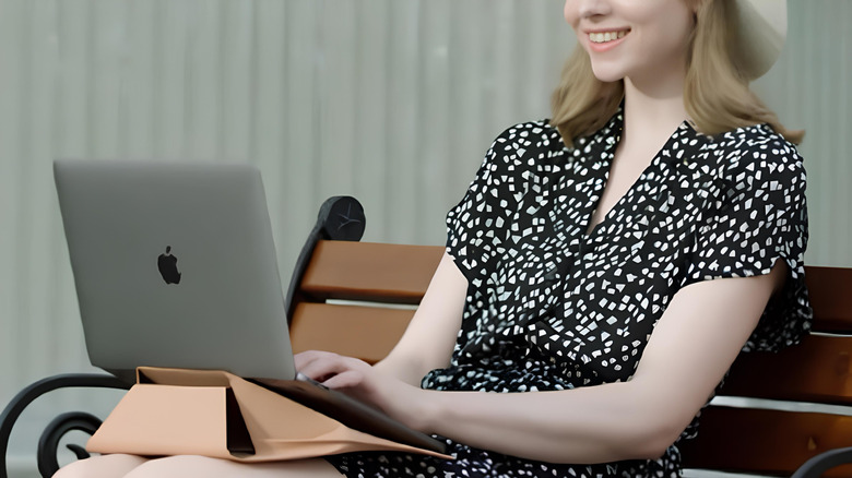 Woman using a brown Moft carry sleeve as a stand on her lap