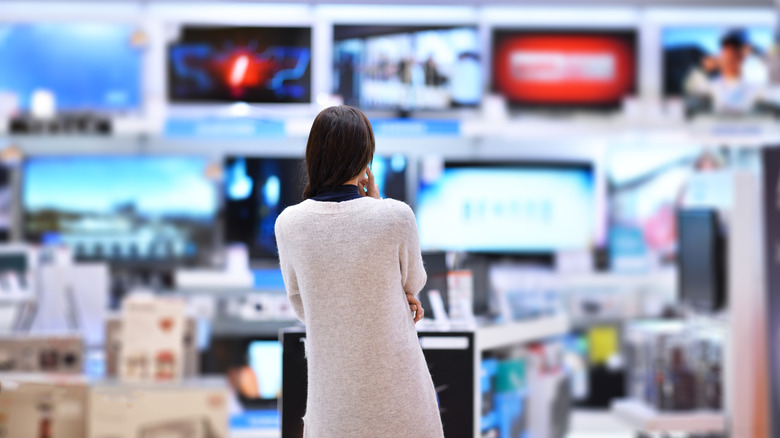 Lady looking at TVs