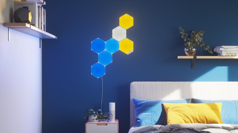 The Nanoleaf Shapes smart lighting panels installed on the wall of a bedroom.