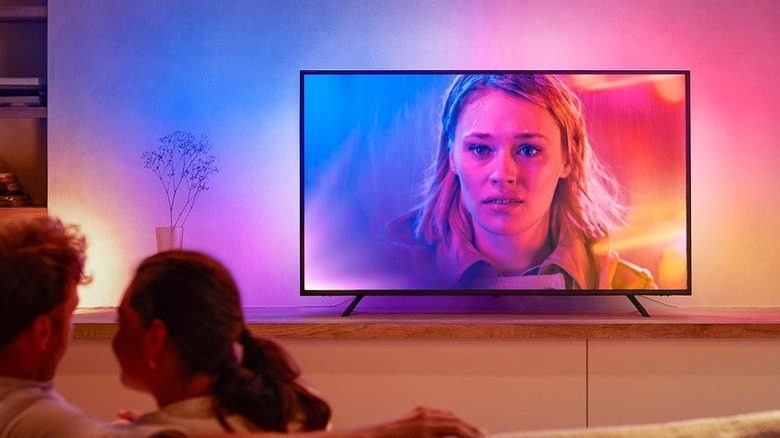 The Philips Hue Play Gradient smart light strip installed behind a TV in a living room.