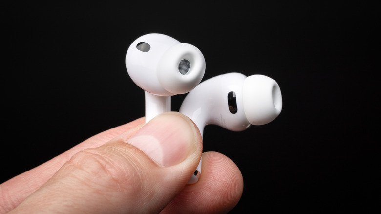 A person holding a pair of Apple AirPods Pro 3.