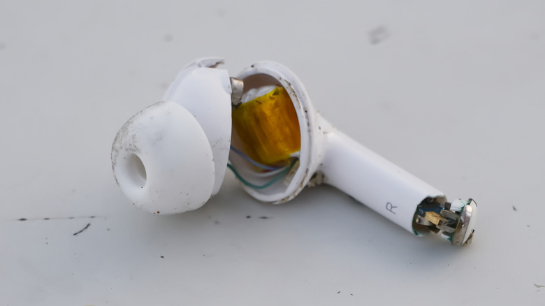 A broken Apple AirPod on a table.