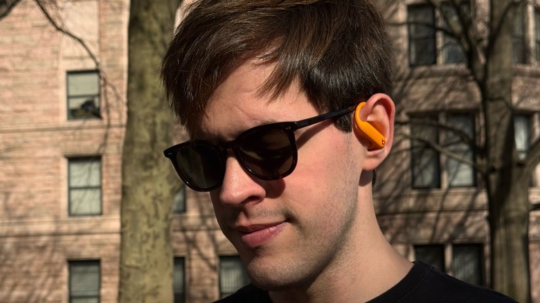 Man wearing the Powerbeats Pro 2 in orange