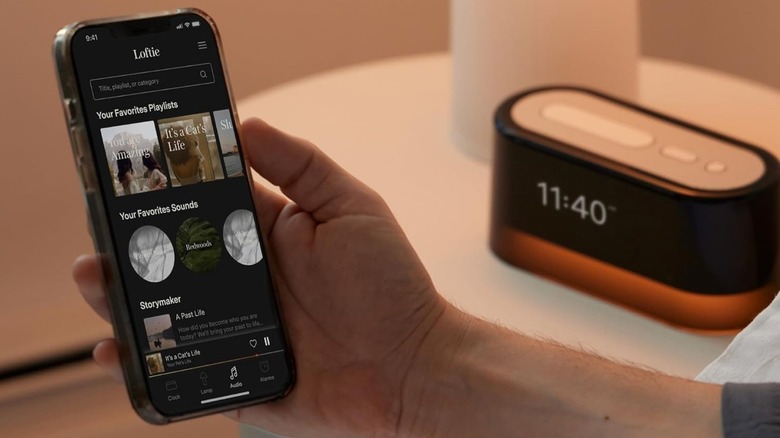 Loftie Alarm Clock on nightstand with its mobile app visible.