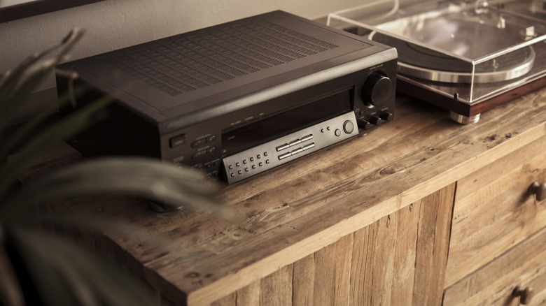 A modern home audio amplifier next to a turntable.