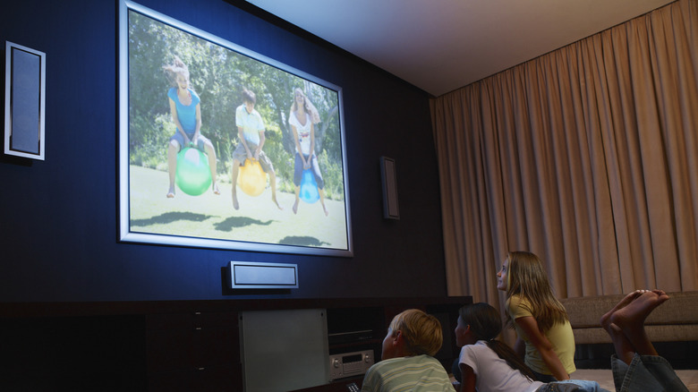 Three children looking at a TV display