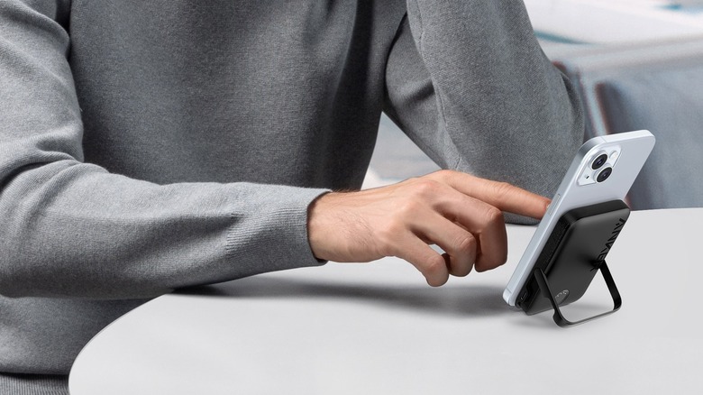 A person using the Magnetic Wireless Charging 5,000mAh Power Bank to charge their iPhone