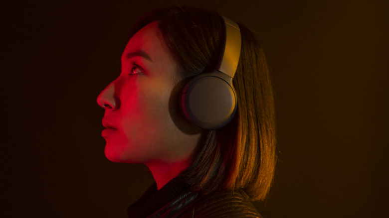 Asian woman listening to music with wireless headphones