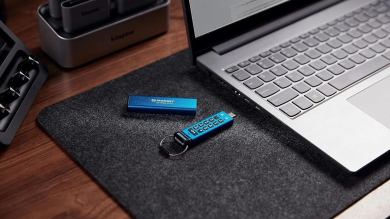 A Kingston IronKey Keypad 200 drive next to a laptop