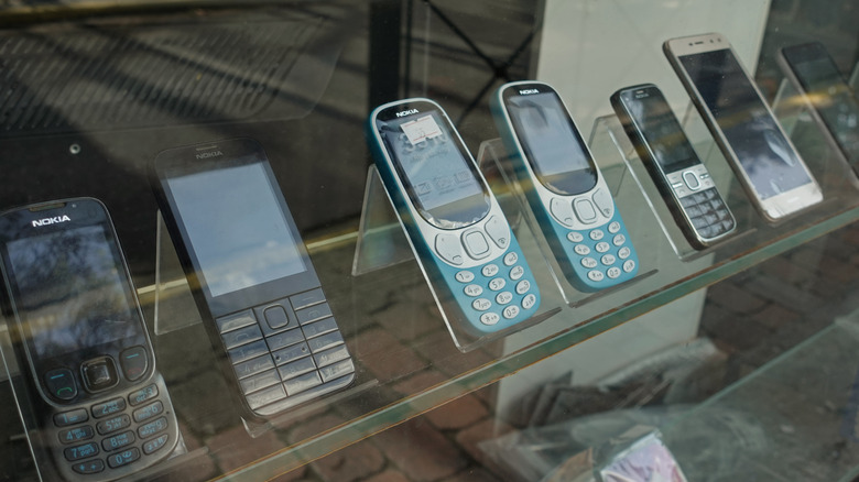 A display of mobile phones, mostly older Nokia phones