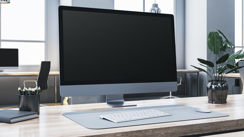 A computer monitor sitting on a desk in a modern office.