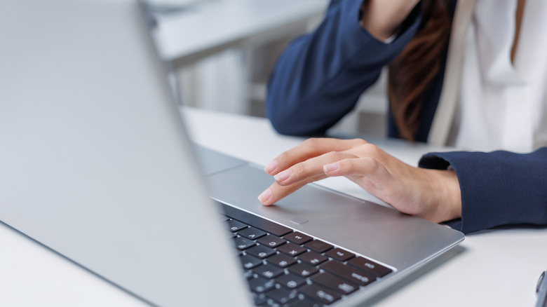 A person using a laptop trackpad.