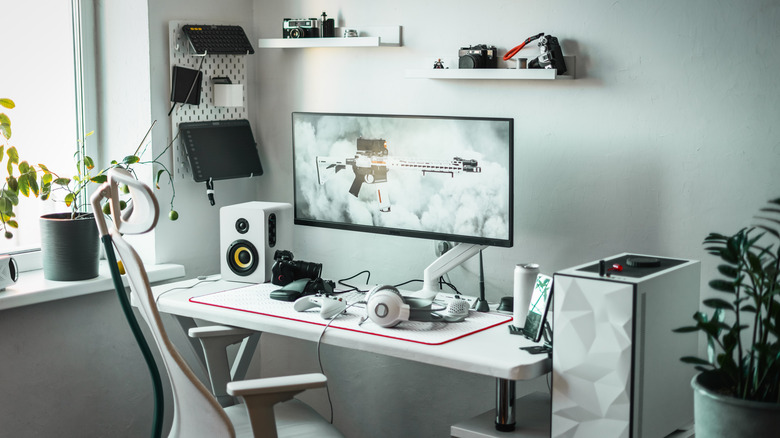 Image of  a gaming PC setup with an ultrawide monitor and various peripherals