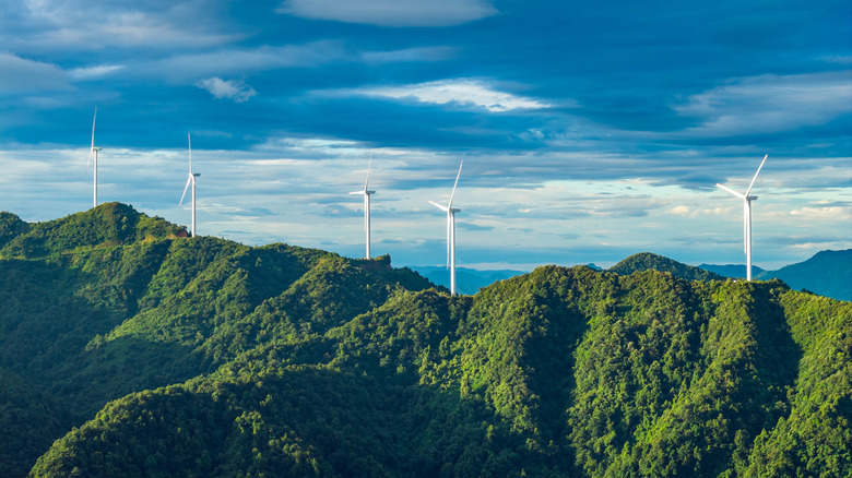 Wind turbines on top of green mountains