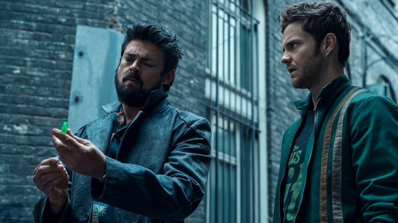 Billy Butcher (Karl Urban) and Hughie (Jack Quaid) looking at a syringe in an alleyway in The Boys