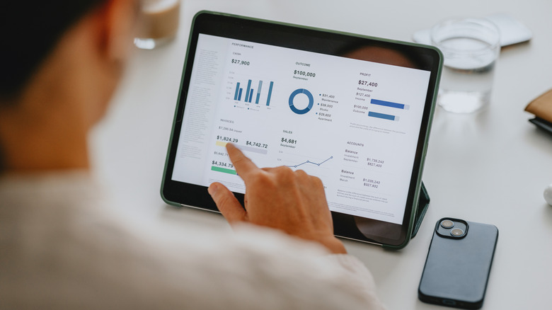 a person looking at financial graphs on a tablet