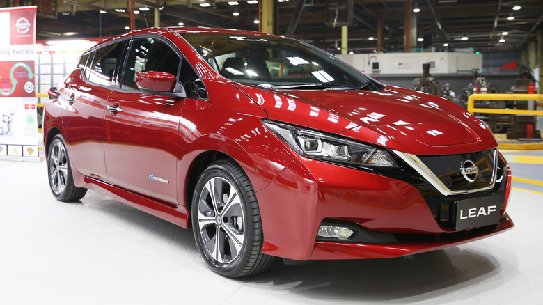 one of the cheapest electric vehicles, a red Nissan Leaf, in a showroom