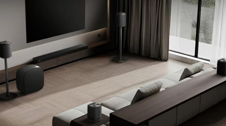 An LG Sound Suite system set up in a living room, featuring an H7 Soundbar, M5/M7 speakers, and a W7 subwoofer.