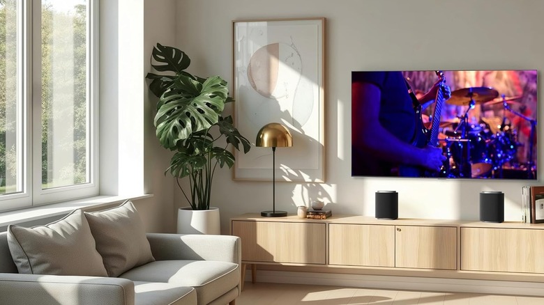 The LG Sound Suite M5 speakers set up below a wall-mounted TV.