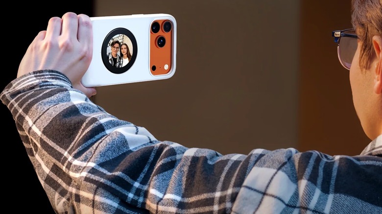 A person using the Selfix case's display to take selfie photos on an iPhone 17 Pro.