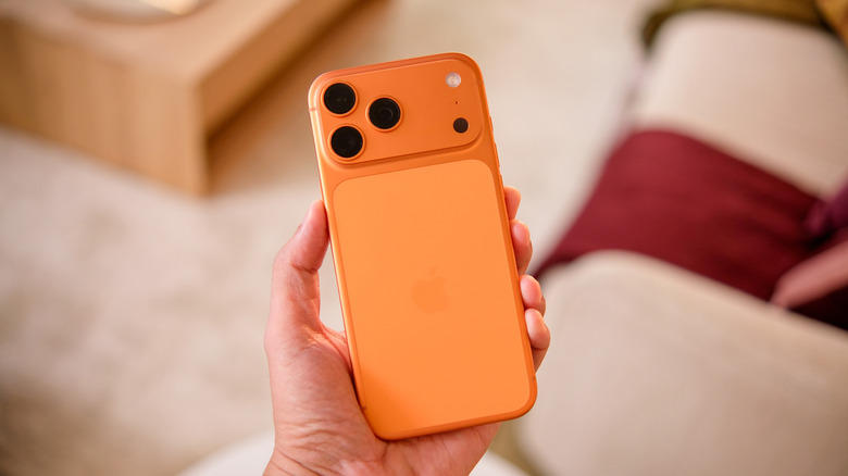 The iPhone 17 Pro (Cosmic Orange) in hand.