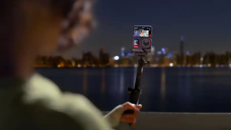 Person holding a selfie stick attached to a Ace Pro 2 camera