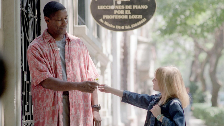Denzel Washington as John Creasy receives a flower from a young girl.