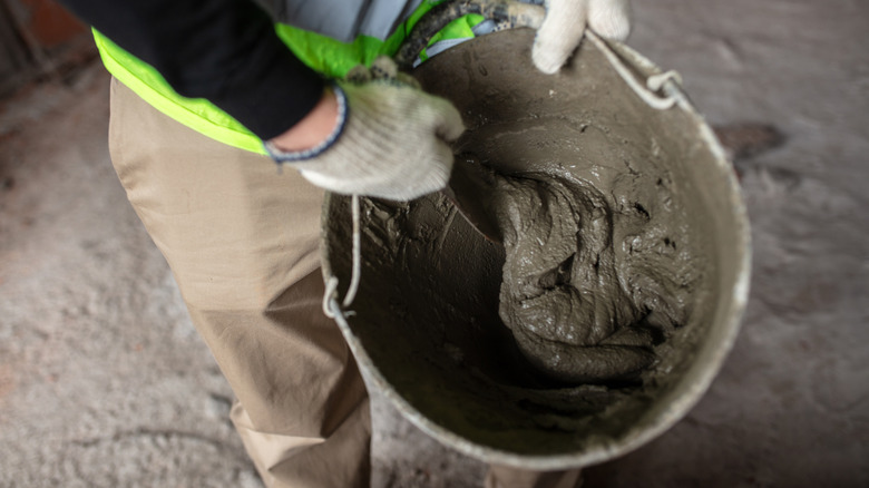 Worker mixing a bucket of mortar