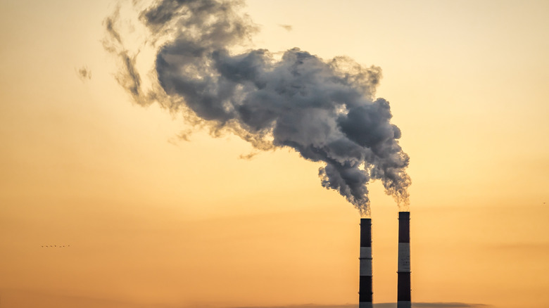 Two industrial chimneys blowing smoke