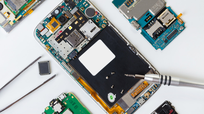 A smartphone in the middle of being repaired is pictured against a white backdrop.