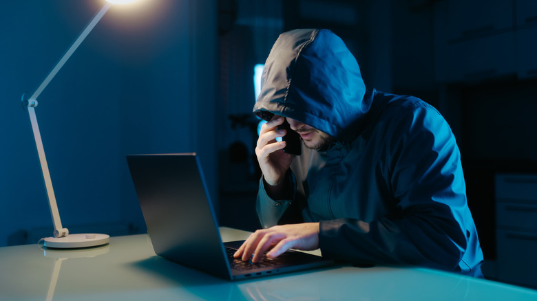 Hacker on a laptop in a dark room