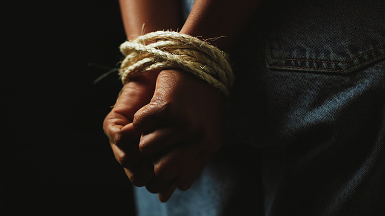 a person's hands tied behind their back with rope