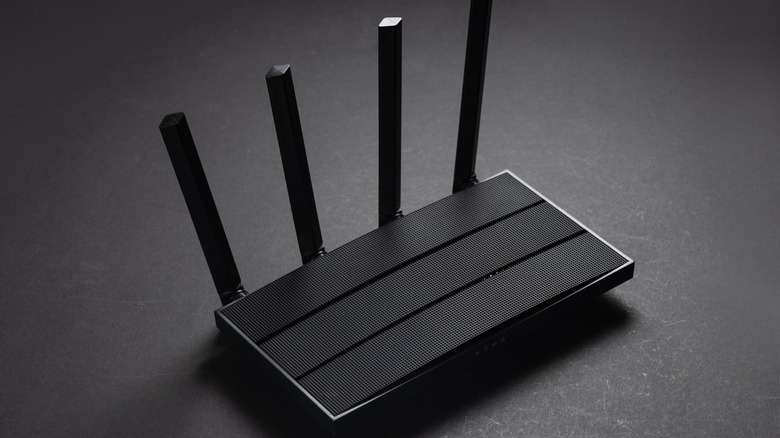 Black wi-fi router against a black background