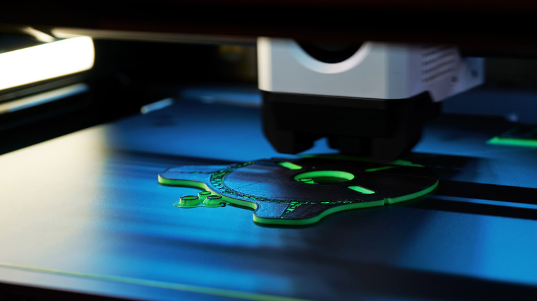 3D printer creating small green cog-like object