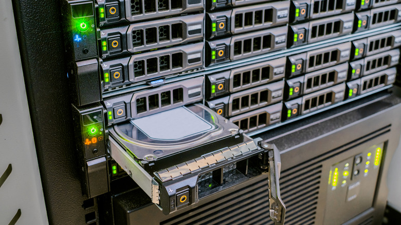 Single hard drive ejected from large web server rack.