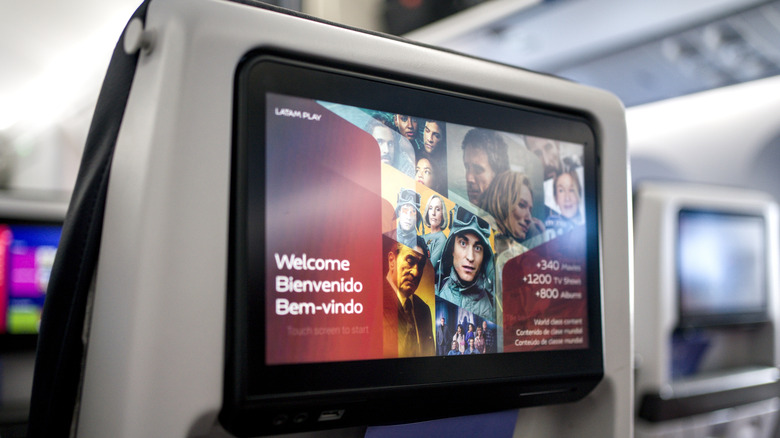 A screen displaying in-flight entertainment options on a passenger plane