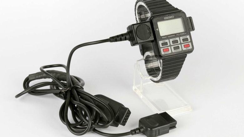 A Seiko RC-1000 smartwatch on a stand with cord attached