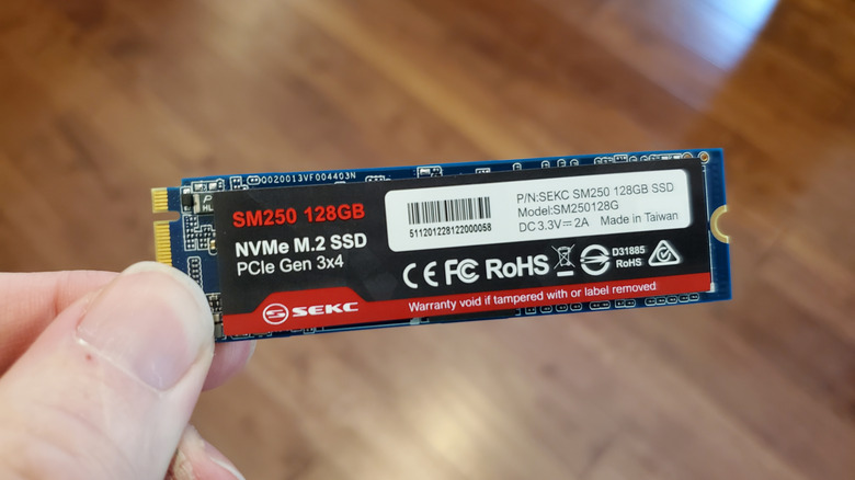 A hand holding an SSD card for a PC