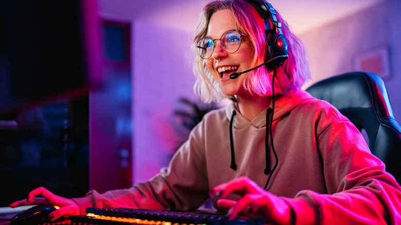 A woman gaming on her PC and looking happy