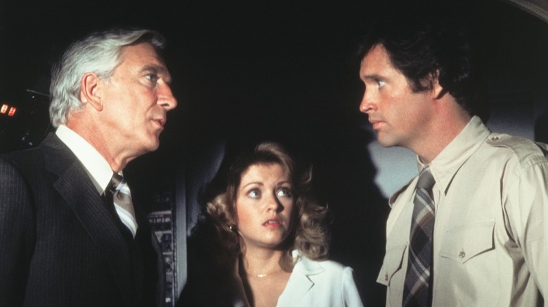 Leslie Nielsen, Robert Hays, and Lorna Patterson looking at each other in Airplane!