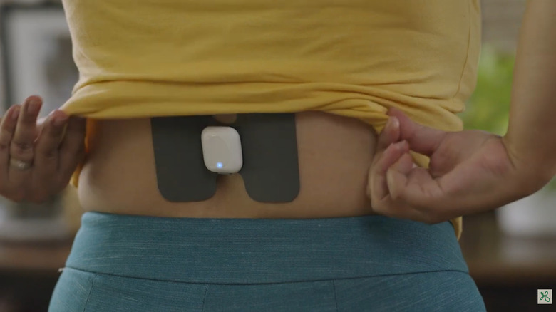 Woman wearing Hinge Health's health tech wearable, Enso, on her back
