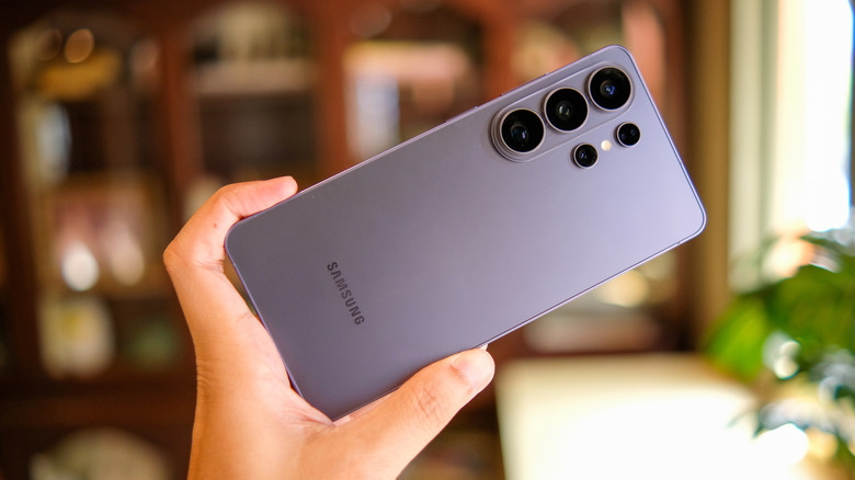 Person holding up the Samsung Galaxy S26 Ultra with the camera and flash visible.